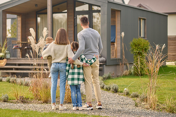Family standing in front of a modern home